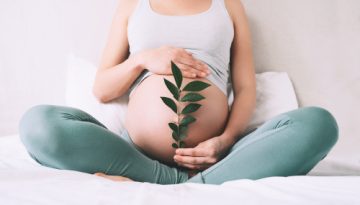 pregnant_woman_holds_green_sprout_plant_near_her_b_2023_11_27_05 1
